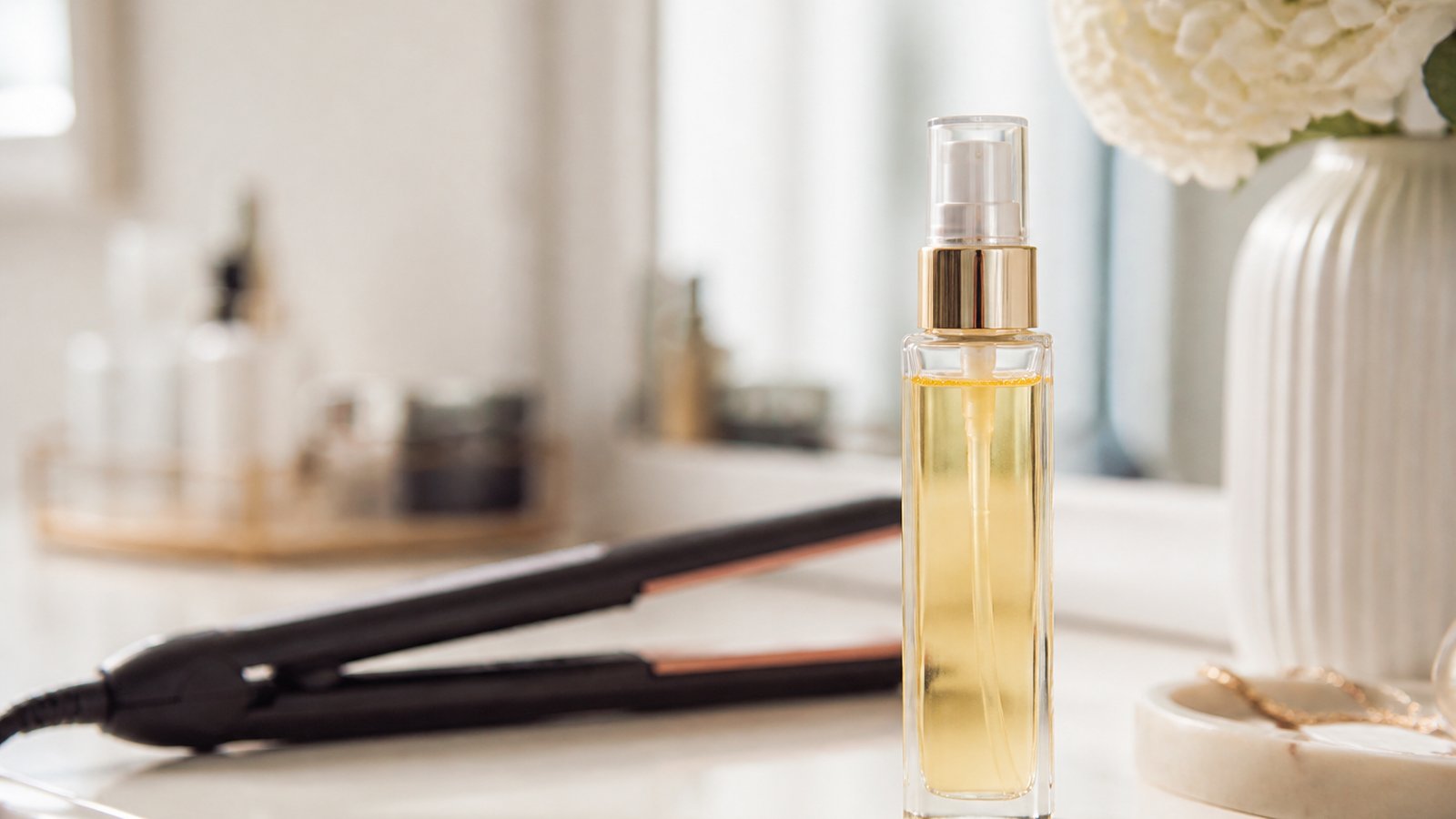 Leave-in serum on a vanity beside smoothed heat-styled ends